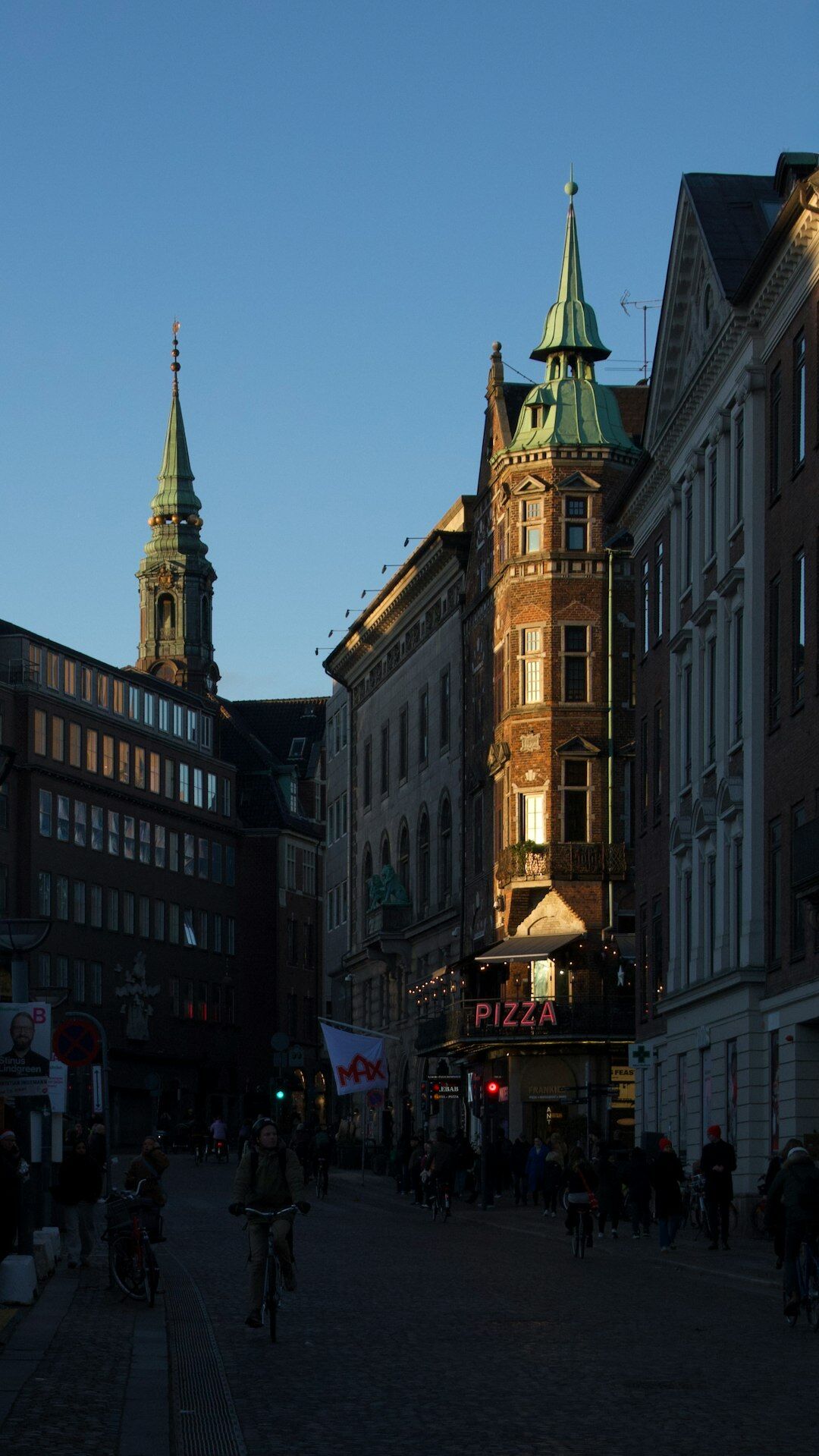 Cyclists on a cobblestone street in a Danish city